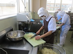 給食室で切干大根を切っているところの写真