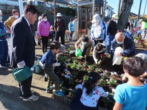 長生クラブの皆さんと子どもたちと市長でパンジーの苗を植える様子