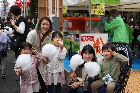 わたあめを食べるこどもたちと保護者