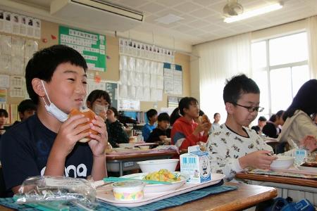 笑顔でハンバーガーを食べる子どもたち