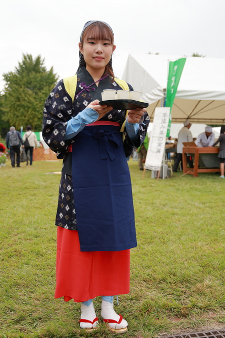 茶娘の恰好をした女性が試飲用の狭山茶をお盆で持っている様子。