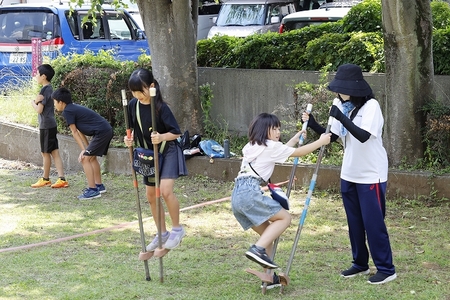 外の芝生で竹馬体験